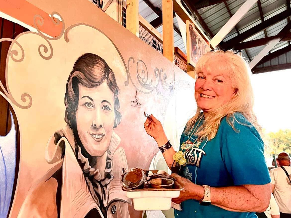 Artist Christine DeShazo painting a mural