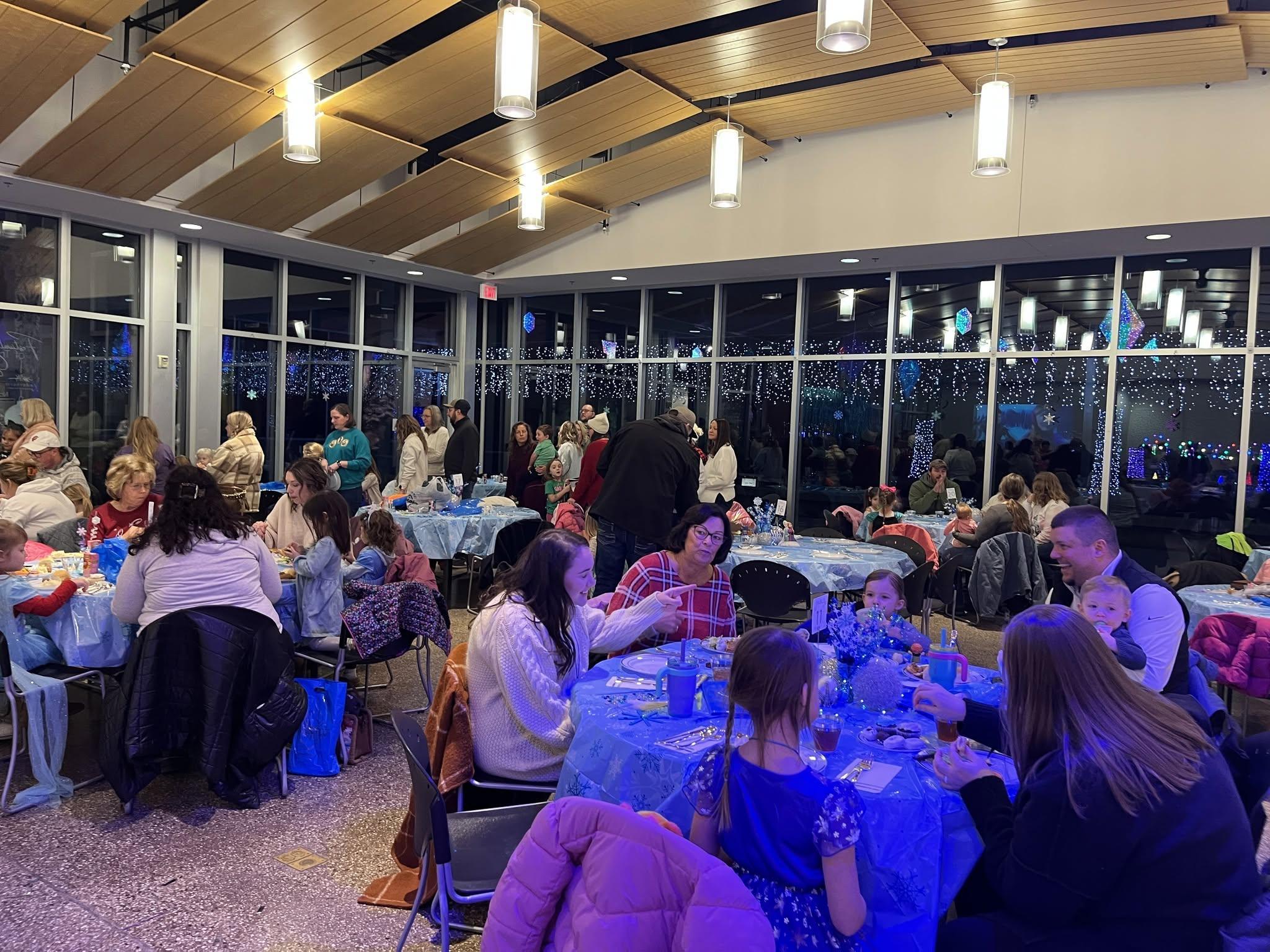 Several families gather around tables to eat